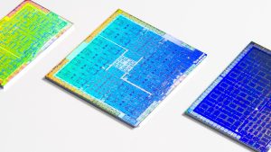 Three colorful GPUs with their packaging cleanly removed laying on a white surface. Credit: Fritzchens Fritz